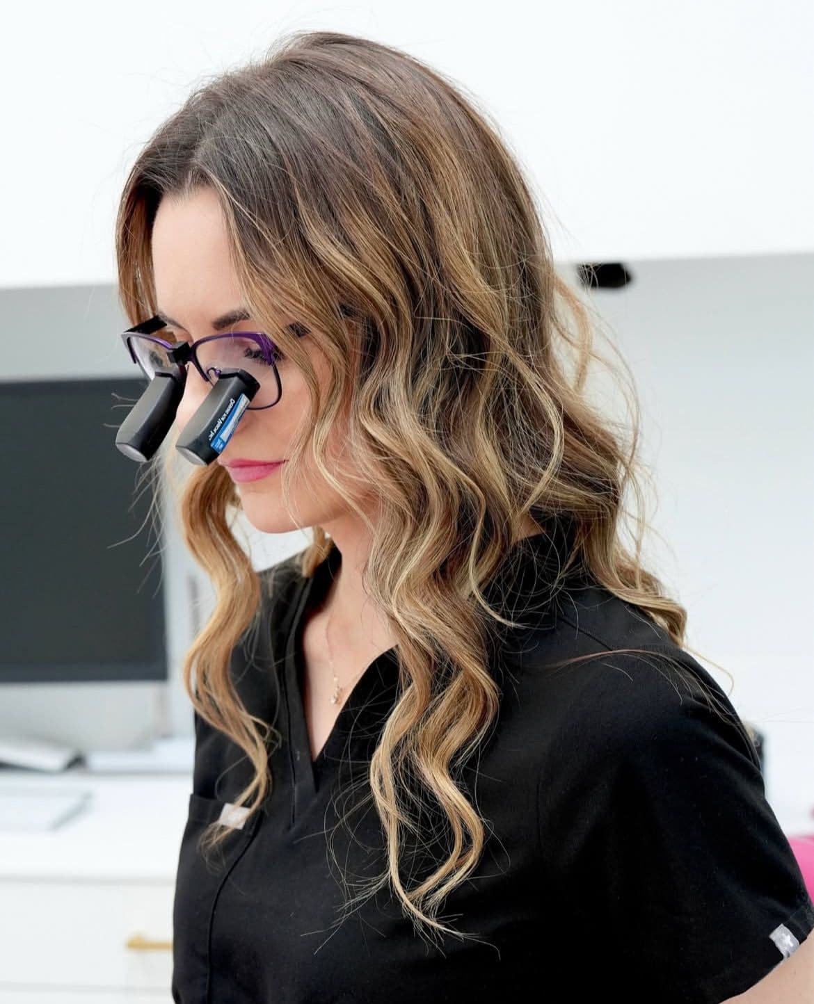 Dental team member using clinical loupes for precision care at Transcend Vancouver